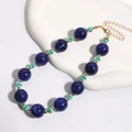 Detail van blauwe marmeren kralenketting met gouden karabijnsluiting en verstelbare ketting - KC Goud / Saffierblauw