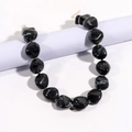 Dettaglio delle perle con trama marmorizzata e distanziali dorati sulla collana - Nero