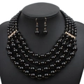 Detail van de vijflaagse zwarte kralenketting en oorbellen set met gouden strass-accenten - Zwart