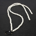 Detalle de cadena de pelo con perlas blancas y clip BB negro sobre fondo con purpurina - Estilo de Perla de Doble Capa (12200B)
