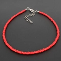 Bohemian choker necklace featuring red seed beads and silver heart-shaped charm chain - Red