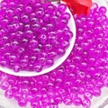 Macro shot of 8mm translucent purple glass beads in a ceramic dish for DIY jewelry making - Purplish Red