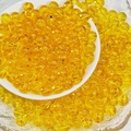 Macro shot of 8mm bright yellow transparent glass beads for DIY bracelet jewelry making - Gold