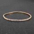 Sparkling rainbow rhinestone elastic bracelet with gold base on a textured black background - AB Color