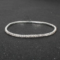 Macro detail of sparkling silver rhinestone tennis bracelet on a black textured background - Silver