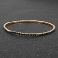 Macro view of gold-plated tennis bracelet with intricate black crystal inlay detail - Black