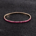 Macro shot of rose gold elastic bracelet with sparkling round pink rhinestones - Rose Red