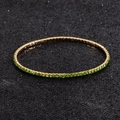 Macro detail of elastic tennis bracelet with green crystals and gold-plated finish - Grass Green