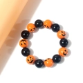 Halloween beaded bracelet featuring orange pumpkin face charms and glossy black resin beads - Bangle