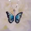 Exquisito collar de mariposa plateada con alas de resina azul e incrustaciones de cristal - Mariposa Multicolor (A2882)
