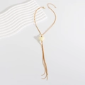 Detail of gold snake chain necklace featuring a cream heart pendant and lobster clasp - White
