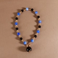 Kralenketting met blauwe en zwarte kralen en een grote bolvormige hanger met gouden sluiting - Blauw