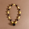 Korte kralenketting met zwarte en honinggele kralen en gouden metalen details - Geel