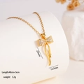 Golden bow pendant necklace with sparkling cubic zirconia on a white pedestal - Bowknot (1666)
