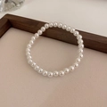 Close-up of elegant 6-8mm white pearl elastic bracelet on a neutral textured surface - 6mm Pearl / Electroplating