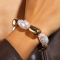 Detail eines elastischen Armbands mit Barockperlen und polierten Goldperlen am Handgelenk - Barockperle Gold Industrial Armband (NK27810)