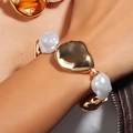 Nahaufnahme eines goldenen Armbands mit Barockperlen und hochglanzpolierten Metallelementen - Gold Weiß Vintage Barockperle Armband (NK27840)