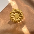 Exquisite golden titanium steel ring with a textured floral design on silk fabric - Radiant Flower (JZ-YS415)