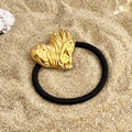 Détail d'un élastique à cheveux noir avec un cœur doré texturé sur une plage de sable - Style Cœur Texturé (FS-YS05-2)