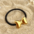 Détail d'un nœud en métal doré minimaliste sur un élastique noir sur un fond de sable doux - Style Nœud Papillon (FS-YS05-1)