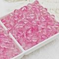 Vue détaillée de perles en verre rose translucide de 6-10mm dans un plateau blanc ajouré - Style Rouge Cardamome (A32) / 8mm (Moyen)