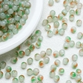 Macro view of 8mm translucent jelly glass beads with green and orange floral patterns - Cyan-Yellow Gradient (A8)