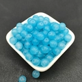 Close-up of translucent blue glass beads for DIY jewelry making on white ceramic plate - 8mm / Sky Blue