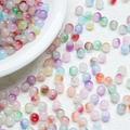 Mix of 8mm gradient jelly glass beads in a white porcelain tray for DIY jewelry making - Multicolor