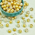 Close-up of 8-10mm gold and ice-cracked glass beads in a green ceramic bowl for DIY jewelry - Semi-Gold Crackle (E44#)