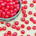 Close-up of red crackle glass beads in a dark green bowl for DIY jewelry making - Red Snowflake Crackle (M389#)
