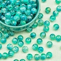 Close-up of translucent emerald green glass beads with decorative gold crackle textures - Blue-Green Silk Crackle (H204#)