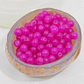 Macro view of bright magenta chalcedony glass beads for DIY jewelry on stone tray - 8mm / Fuschia