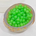 Close-up of translucent bright green round beads with pre-drilled holes for DIY jewelry - 4mm / Apple Green