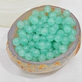 Macro shot of 8mm translucent pale green chalcedony beads with holes in a stone bowl - 4mm / Cyan Blue