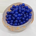 Macro shot of dark blue translucent round chalcedony beads in a natural stone bowl - 4mm / Dark Blue