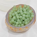 Macro shot of green chalcedony beads with natural translucency in a stone bowl - 10mm / Light Aventurine Green