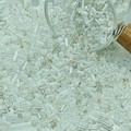 Macro shot of mixed white and transparent glass seed beads spilling from a glass jar - White (M760)