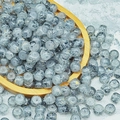 Macro shot of 6x8mm marble pattern glass beads with gold specks in a wooden tray - 6X8mm / Ink Grey