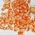 Close-up of 10mm amber glass crackle beads spilling from a glass jar for DIY jewelry - Two-Tone Crackle Style (H206) / 8mm / Golden Orange