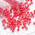 Detail of 10mm red cracked glass beads being poured from transparent storage tubes - Silver Wire Crackle Style (H288) / 10mm / Red