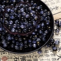 Macro detail of 10mm deep purple cracked glass beads with gold patterns in a black bowl - Two-Tone Crackle Style (H202) / 8mm / Black Khaki