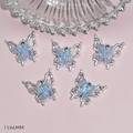 Gros plan sur cinq pendentifs papillon 15x6mm avec inserts en résine irisée couleur AB - Blue (G59)