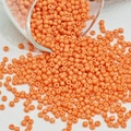Macro-opname van glanzende oranje glaskralen die op een witte achtergrond vallen - Honing Oranje