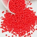 Macro-detail van levendige rode glazen kralen op een witte gestructureerde achtergrond - Rood