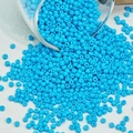 Macro-opname van felblauwe glazen kralen die uit een glas stromen voor DIY-sieraden - 3mm / 10 g / Meerblauw
