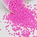 Macro-opname van neon roze glazen kralen voor het maken van DIY-sieraden en hobby's - Roze
