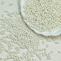 Macro shot of 3x6mm cream white dual-hole glass twin beads for DIY jewelry making - Off-white