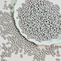 Detailed view of 3x6mm twin-hole lavender glass beads in a white ceramic dish - Gray