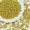 Macro detail of gold-plated dumbbell-shaped dual-hole seed beads for DIY jewelry making - Gold