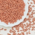 Macro shot of 3x6mm matte cinnamon peanut beads with double holes in a white ceramic dish - Light Coffee